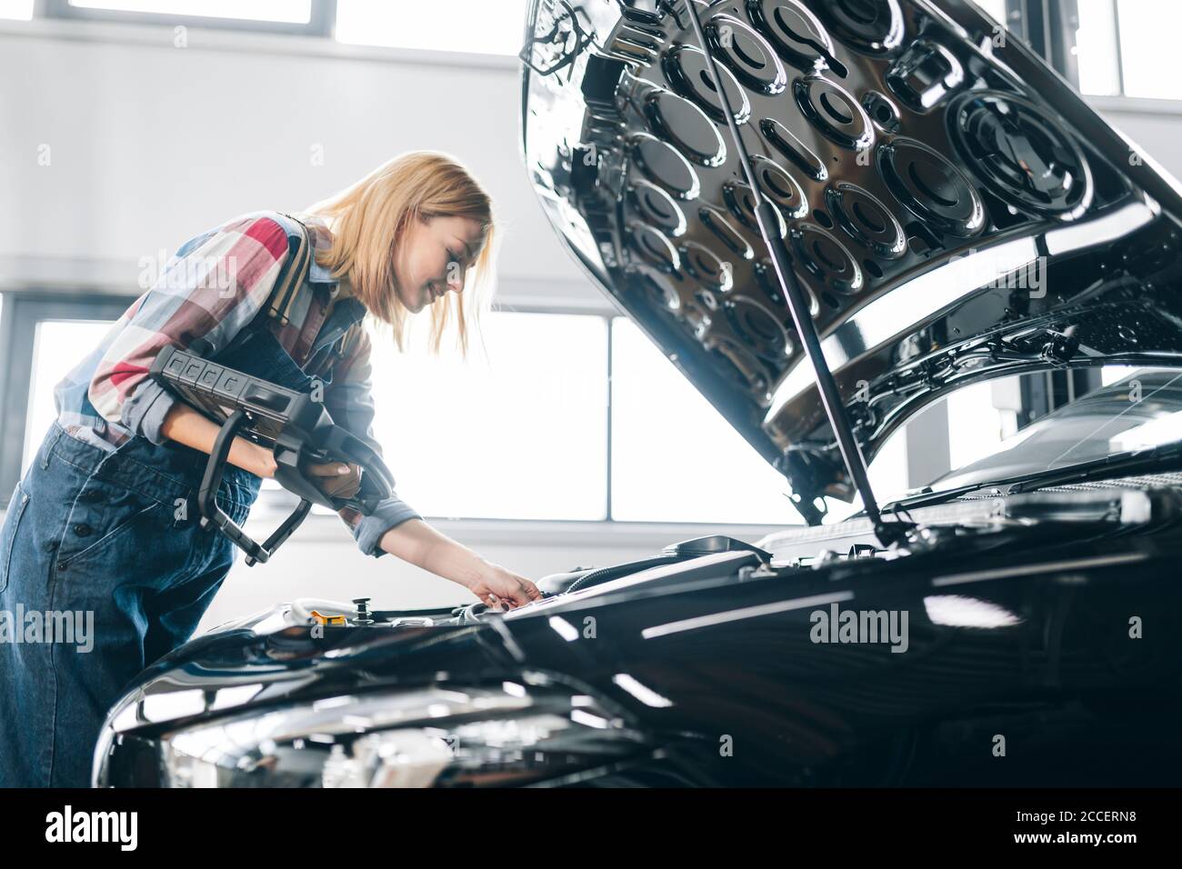 personale che controlla i sistemi di un'automobile e identifica facilmente i problemi. vista laterale foto Foto Stock