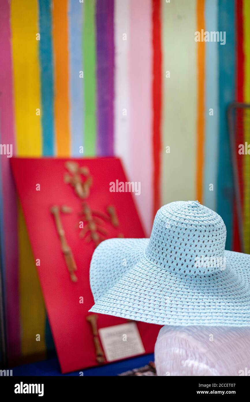 Signora anonima con un cappello floppy guarda una scimmia scheletro su una parete a strisce Foto Stock Signora anonima con un cappello floppy guarda una scimmia scheletro su una parete a strisce Foto Stock