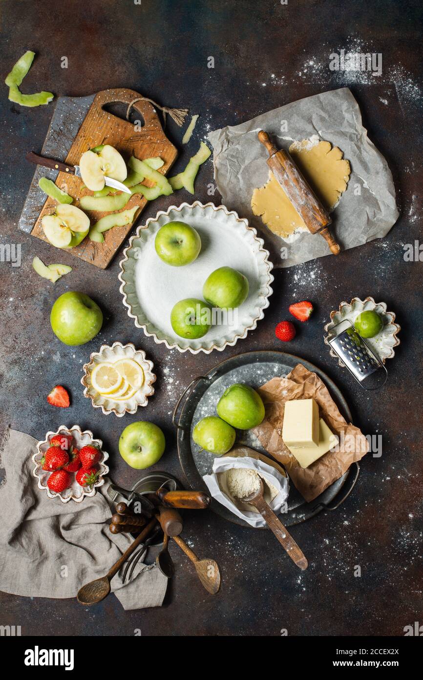 Varietà di prodotti alimentari sul tavolo da cucina. Processo di creazione di torta, vista dall'alto. Foto Stock