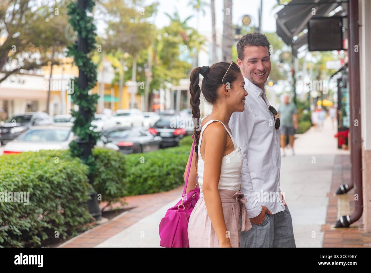 Coppia di città felice in amore giovane uomo e donna a piedi sulla strada dello shopping guardando negozi che parlano insieme, Napoli, Florida, vacanza di viaggio degli Stati Uniti Foto Stock