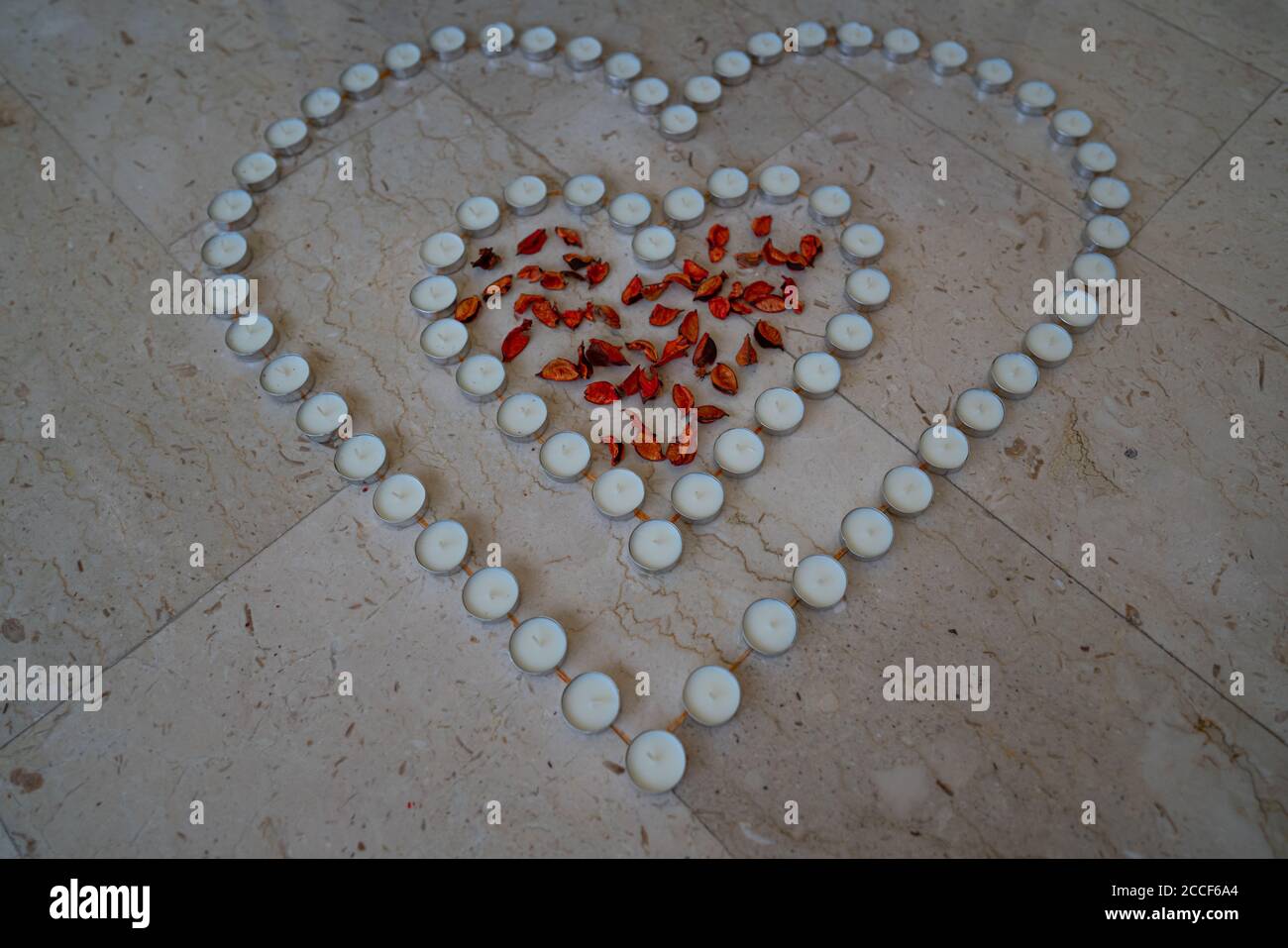 Candele da tè disposte a forma di cuore con Leggi i fogli nel mezzo | festeggiamo anniversari e matrimoni A casa | San Valentino Foto Stock