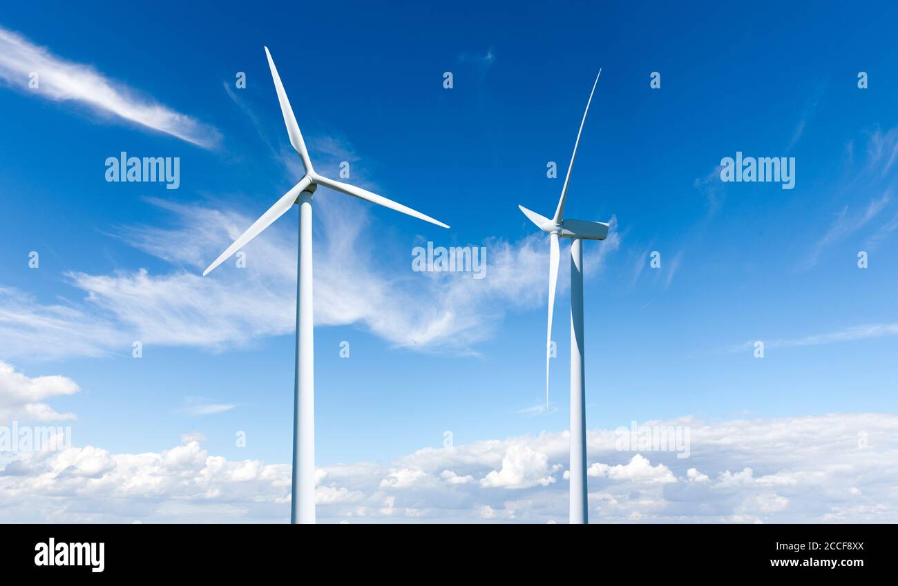 Due turbine eoliche contro un cielo blu Foto Stock