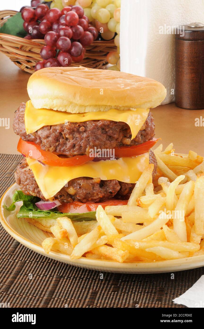 Un hamburger super grande a due piani con patatine fritte Foto Stock