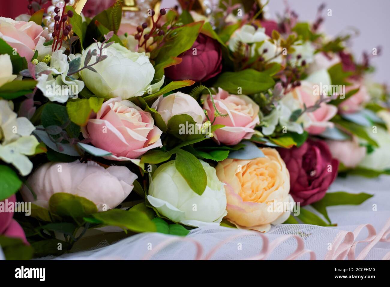 Frammento di una decorazione di nozze, fiori di rosa artificiale, primo piano. Foto Stock