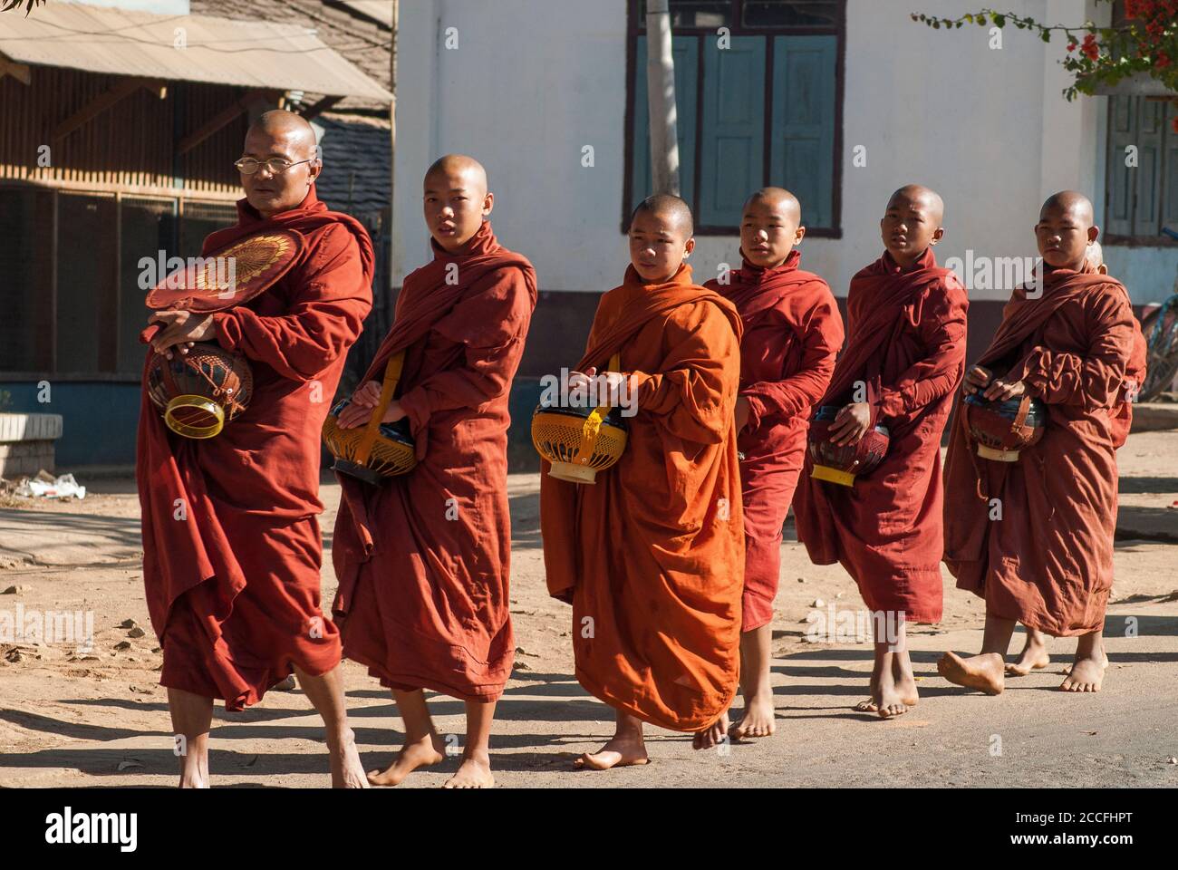 I buddisti credono di guadagnare merito nell'aldilà dando alm ai monaci nelle loro tornate mattutine, Kengtung, Shan state, Myanmar Foto Stock