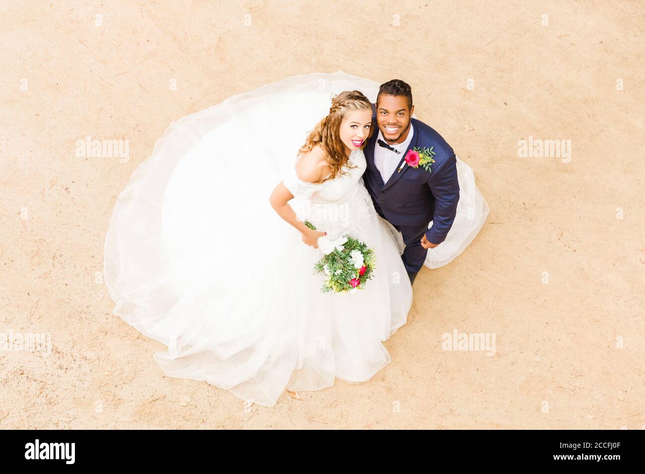 Matrimonio, sposi novelli, giovani adulti, diversità, amore, sabbia, vista dall'alto Foto Stock