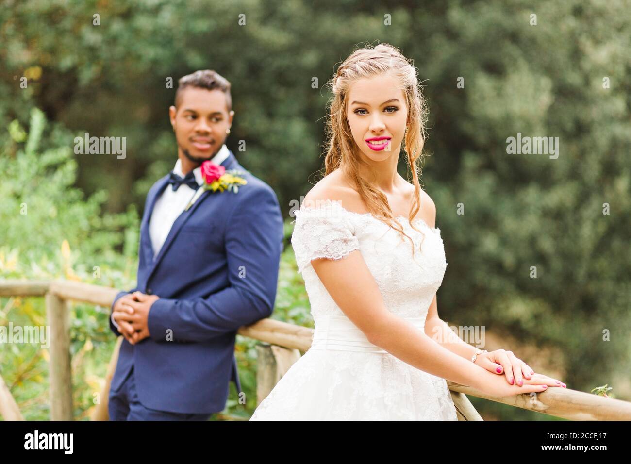 Matrimonio, sposi novelli, giovani adulti, diversità, amore, giardino, ringhiera Foto Stock