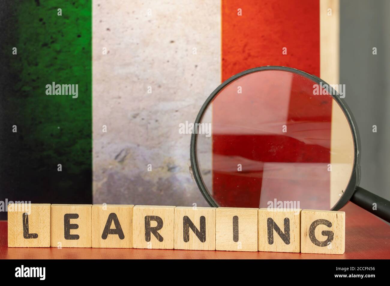 Italian Learning Concept, Flag and Learning word scritto su wood block Foto Stock