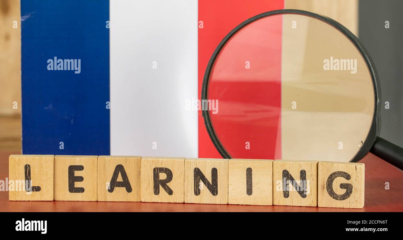 Concetto di apprendimento francese, bandiera e parola di apprendimento scritto su legno blocco Foto Stock
