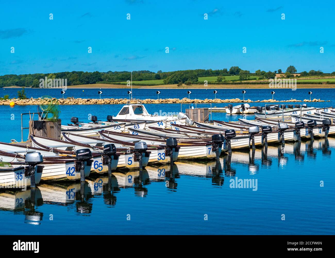 Una linea di barche a motore senza equipaggio per la pesca sulle acque di Rutland – un lago artificiale, lago artificiale e riserva naturale a Rutland, Inghilterra, Regno Unito. Foto Stock