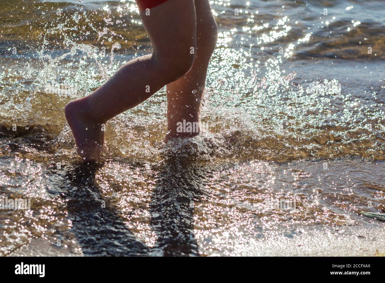 Piedi, e un sacco di gocce d'acqua che spruzzano sullo sfondo della spiaggia Foto Stock