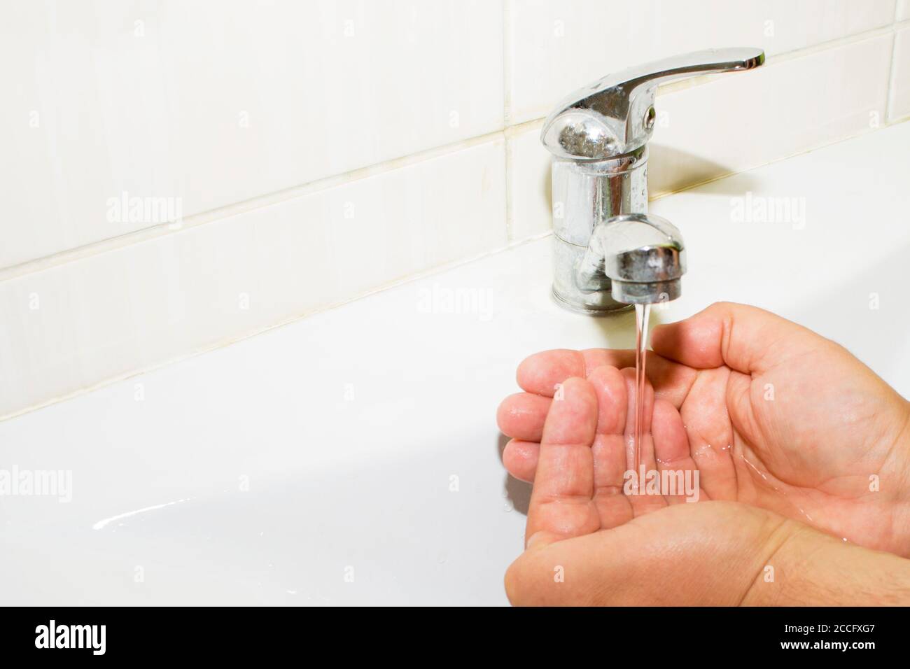 lavabo e acqua corrente dal rubinetto in bagno Foto Stock