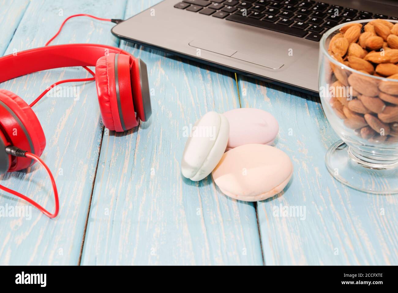 Apri il notebook con coppa di mandorle, marshmallows e cuffie rosse. Foto Stock