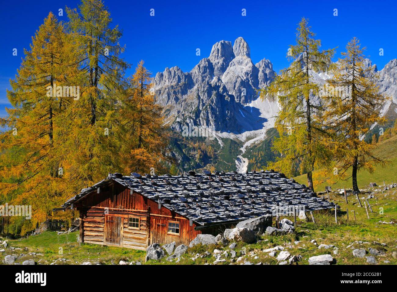 Capanna alpina con cappello vescovile contro cielo blu sul Rettenstein in autunno a Pongau in formato paesaggistico, Foto Stock