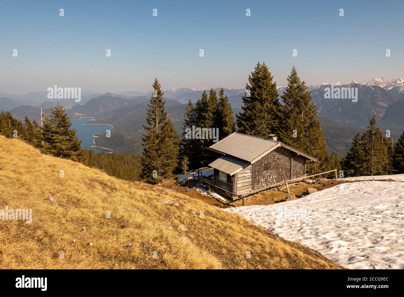 Rifugio di guardia sul Simetsberg con un po' di neve, sullo sfondo il Karwendel e il Walchensee Foto Stock