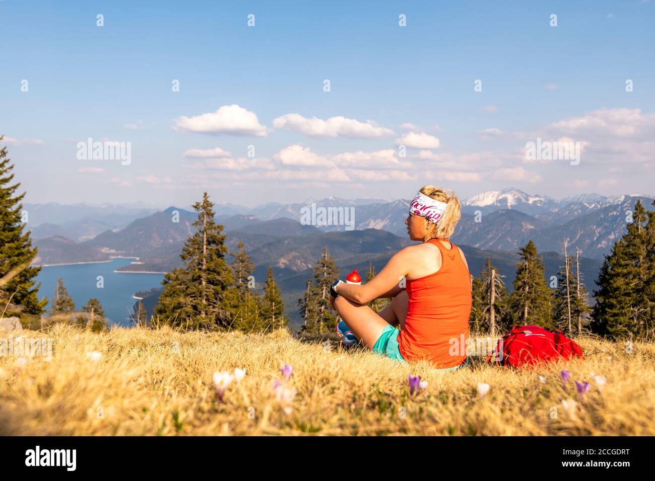 Il corridore Katharina Kirschner gode della vista del Walchensee E le montagne delle Alpi tedesche durante uno sport pausa Foto Stock
