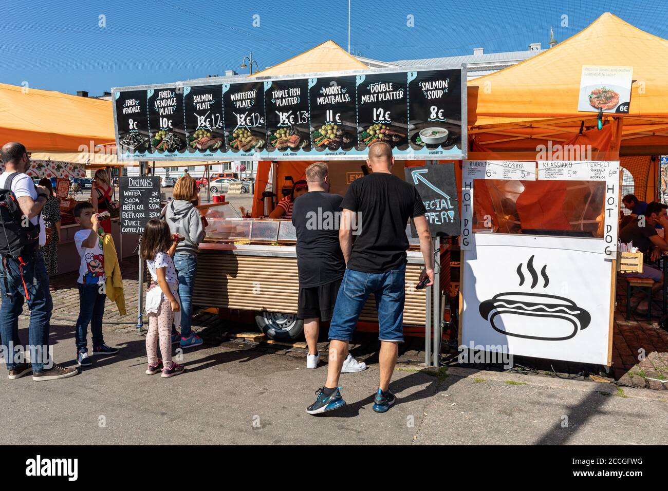 La gente si accosta alla bancarella del venditore di frutti di mare per i piatti di pesce nella Piazza del mercato di Helsinki, Finlandia Foto Stock