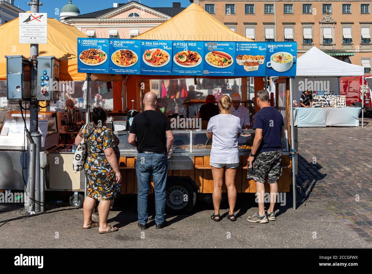 Persone che si accodano al chiosco del venditore di piatti di pesce in Piazza del mercato, Helsinki, Finlandia Foto Stock