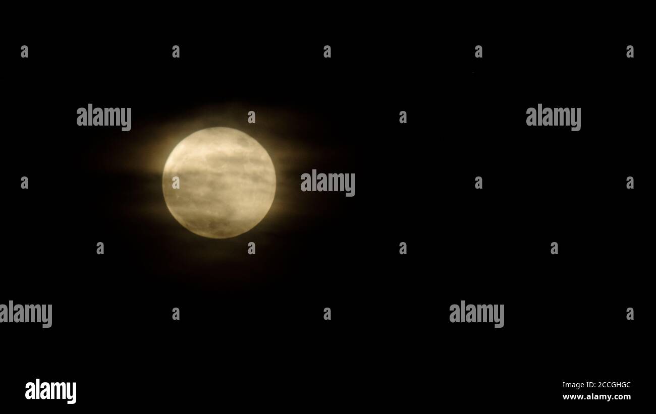Una luna piena coperta di nuvole chiare e foschia che lo rende spooky Foto  stock - Alamy
