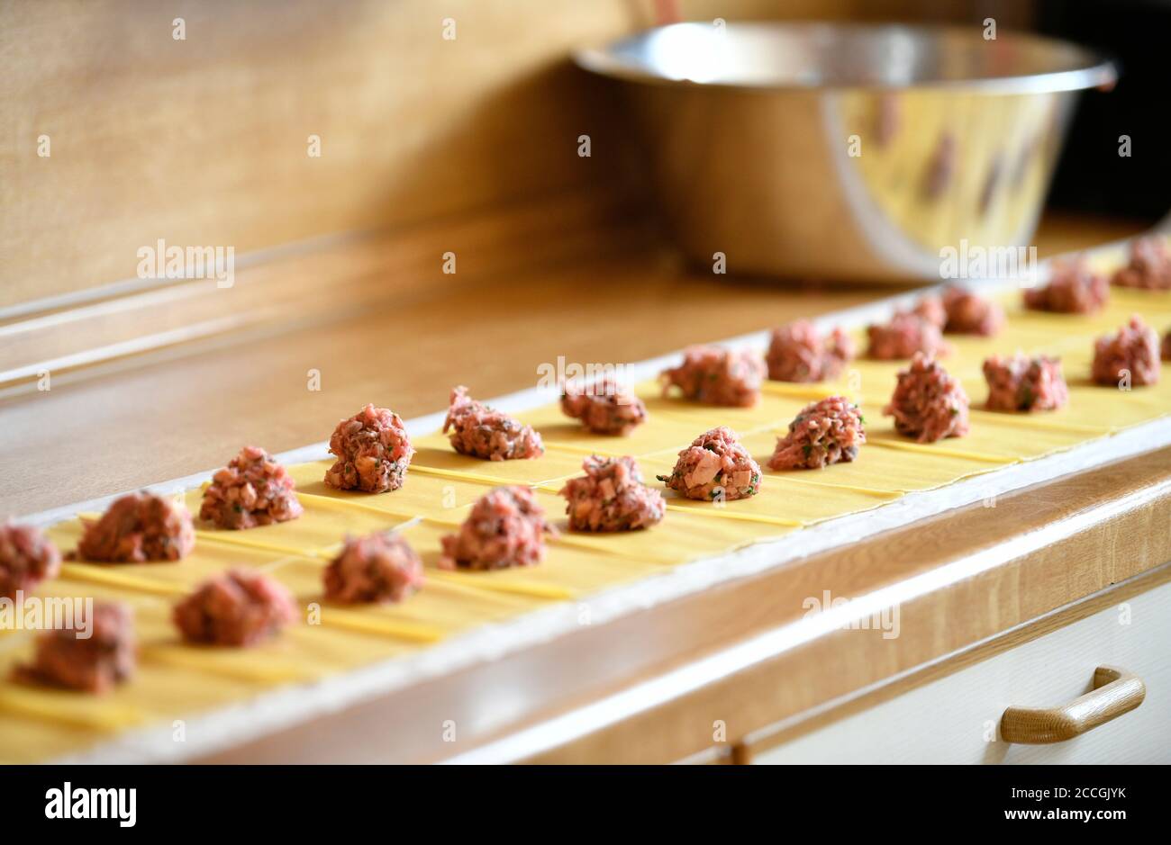 Produzione di gnocchi svevi, porzioni di ripieno di carne giacciono sull'impasto, Stoccarda, Baden-Württemberg, Germania Foto Stock