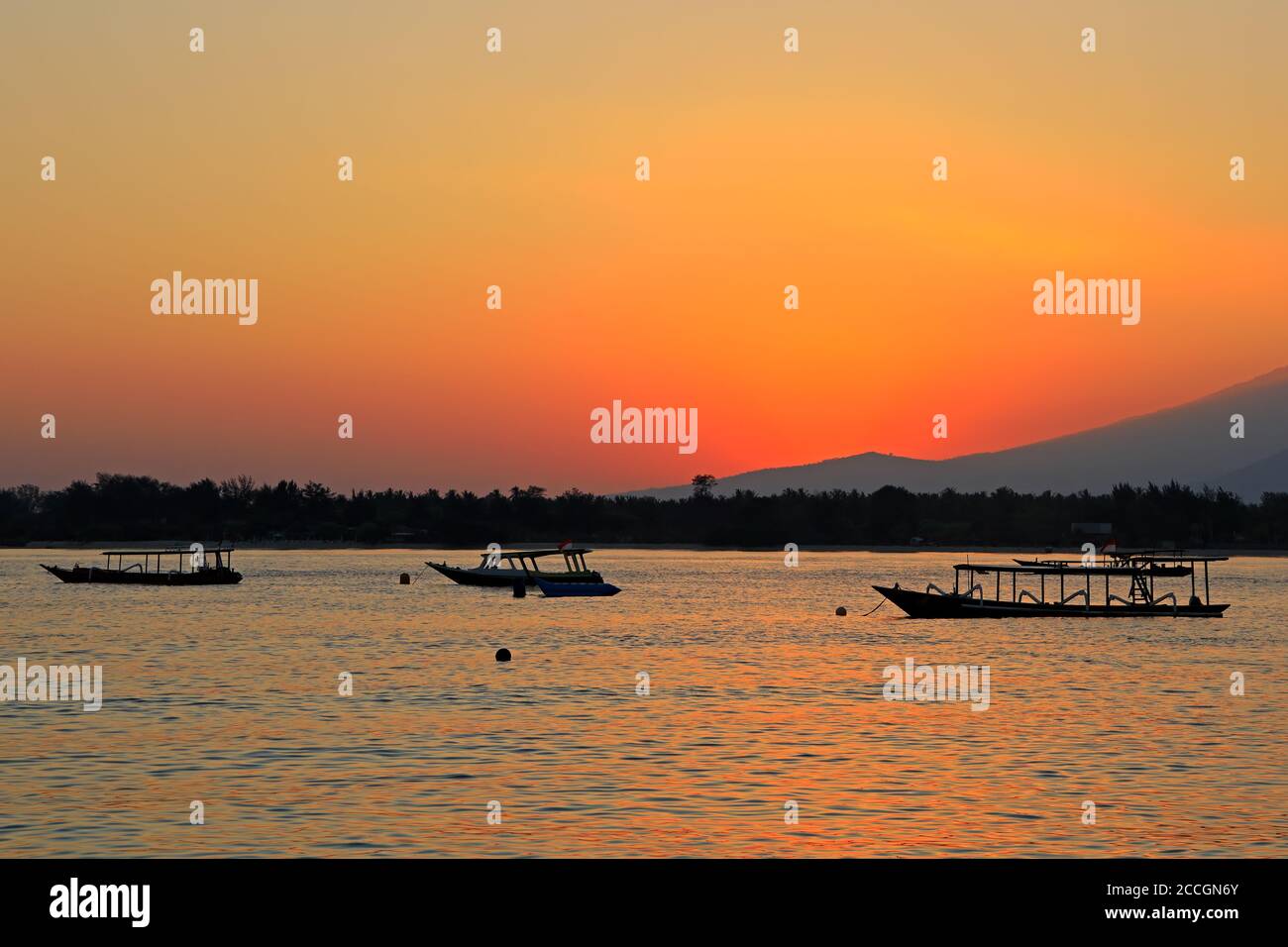 Spiaggia panoramica con barche silhouette al tramonto su un tropicale isola di Indonesia Foto Stock