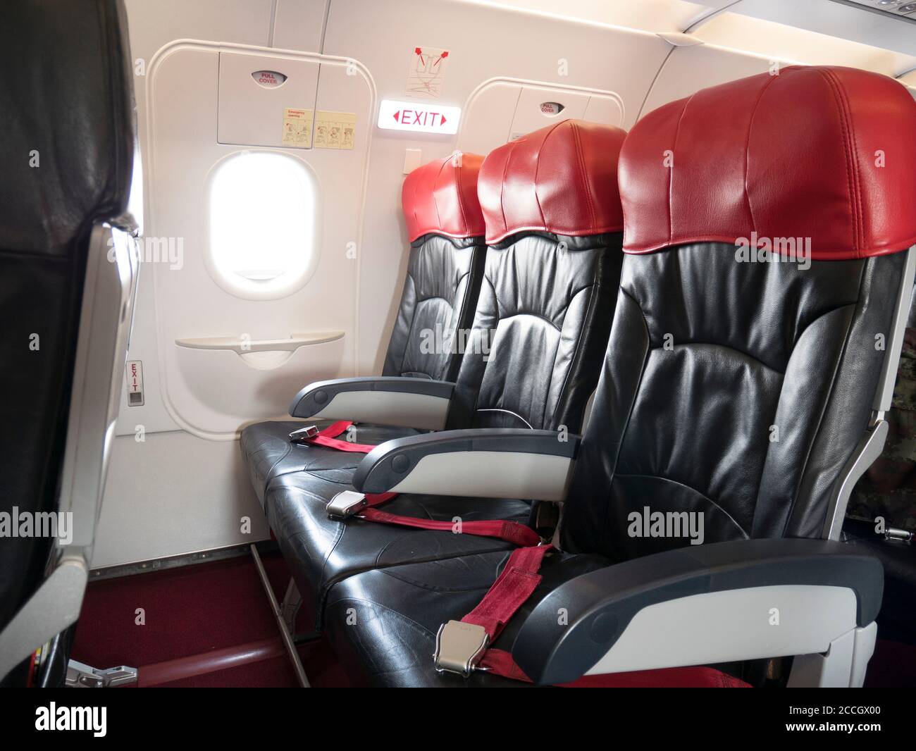 Concetto di sicurezza del volo aereo : fila del sedile di uscita di emergenza in aereo , luce del segnale di uscita sopra l'aereo porta di uscita di emergenza attiva per il passeggero. Foto Stock