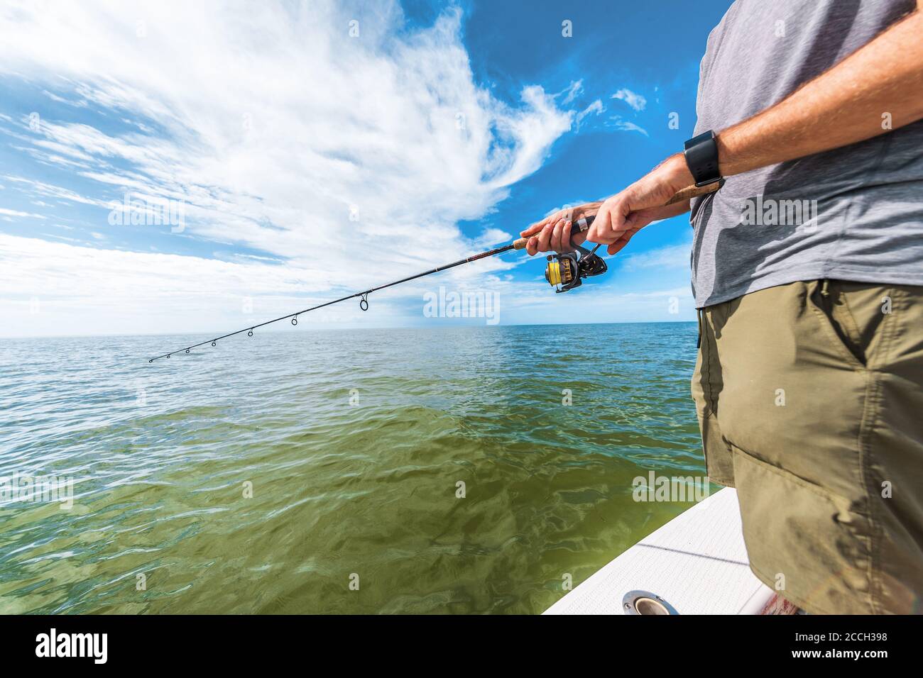 Pesca racchetta uomo ruota pesca da pescatore barca in Florida. Tecnologia indossabile smartwatch per lo sport all'aperto Foto Stock