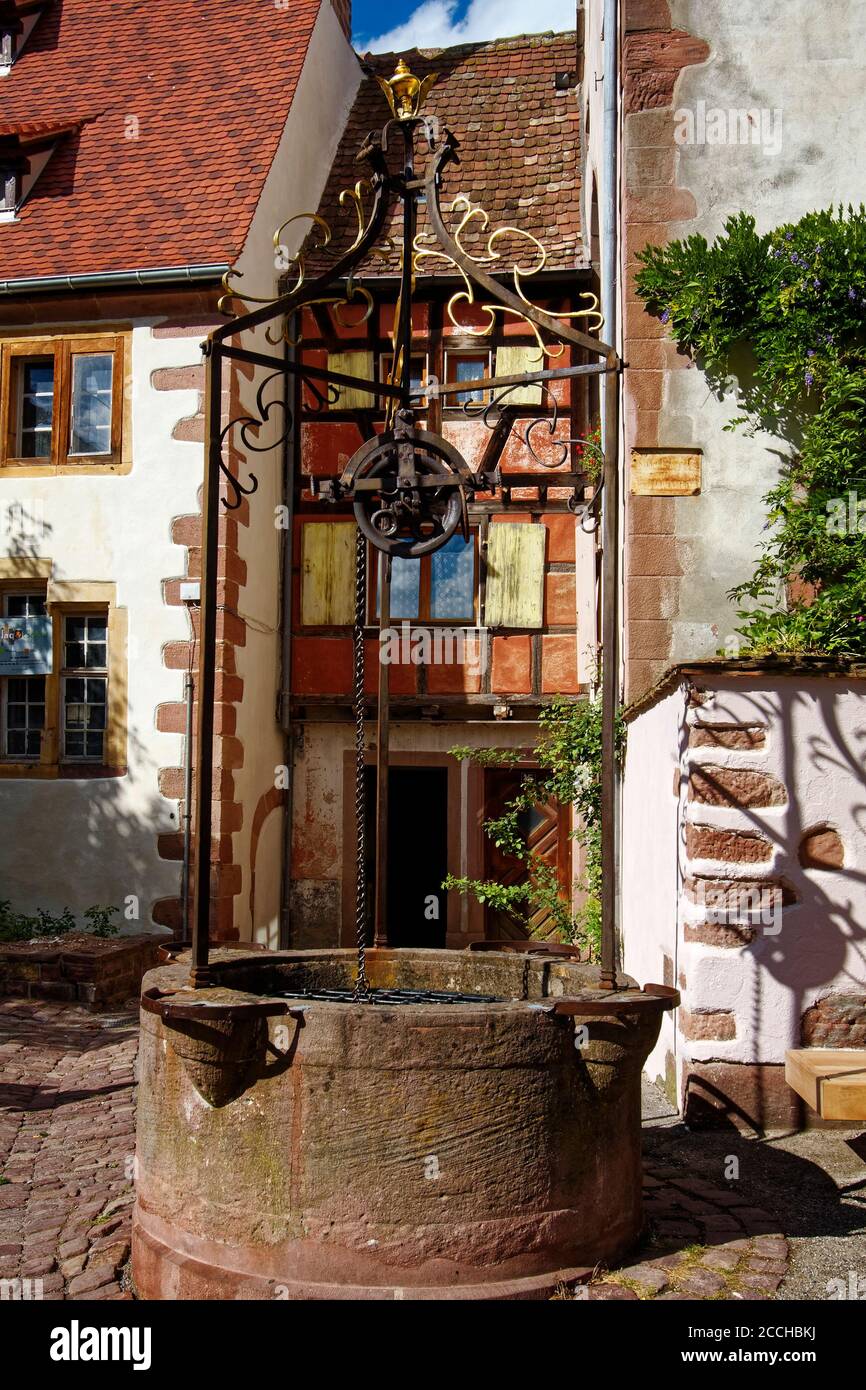 Vecchio pozzo di pietra, ruota, catena, antico, scena di strada; villaggio fortificato; 15-18 secoli; Alsazia; Europa; Riquewihr; Francia Foto Stock