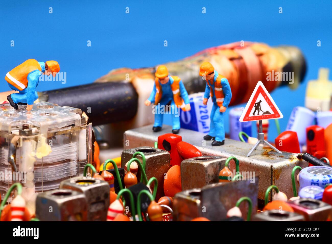 Addetto alla lavorazione in miniatura che ispeziona una radio a circuito stampato vintage concetto di riparazione Foto Stock