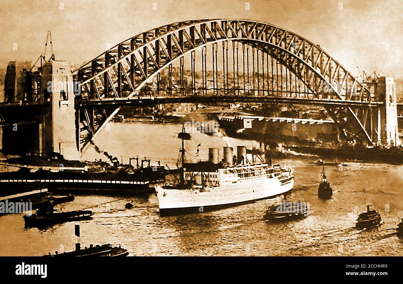 1932 - Tugs che traina una linea P & o (Peninsular & Orient) sotto il ponte del porto di Sydney, NSW, Australia subito dopo che è stata aperta da N.S.W Premier, Jack Lang (soprannominato 'la Grande Fella'). Il suo taglio iniziale del nastro fu interrotto da un uomo (Francis de Groot), a cavallo in una 'Nuova Guardia' (gruppo paramilitare di destra) uniforme militare che lo tagliò con una spada. È stato arrestato e il nastro si è legato nuovamente. I discorsi sono stati fatti dal Governatore del nuovo Galles del Sud, Sir Philip Game, e dal Ministro dei lavori pubblici, Lawrence Ennis. Foto Stock