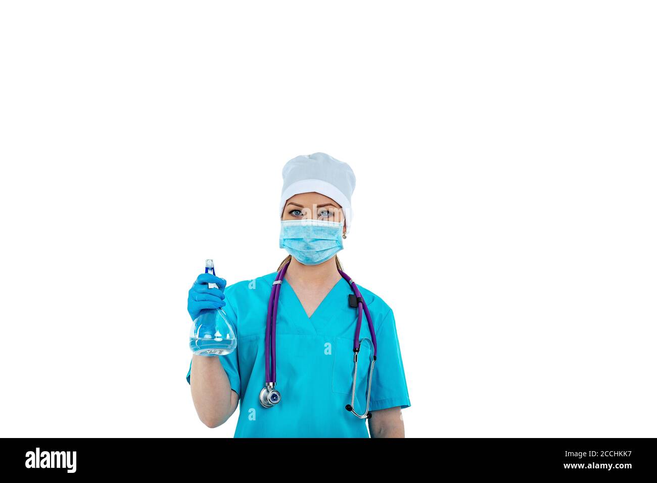 Una dottoressa o un'infermiera in uniforme usa uno spray disinfettante. Disinfezione. Protezione contro virus e batteri. Isolato su sfondo bianco Foto Stock