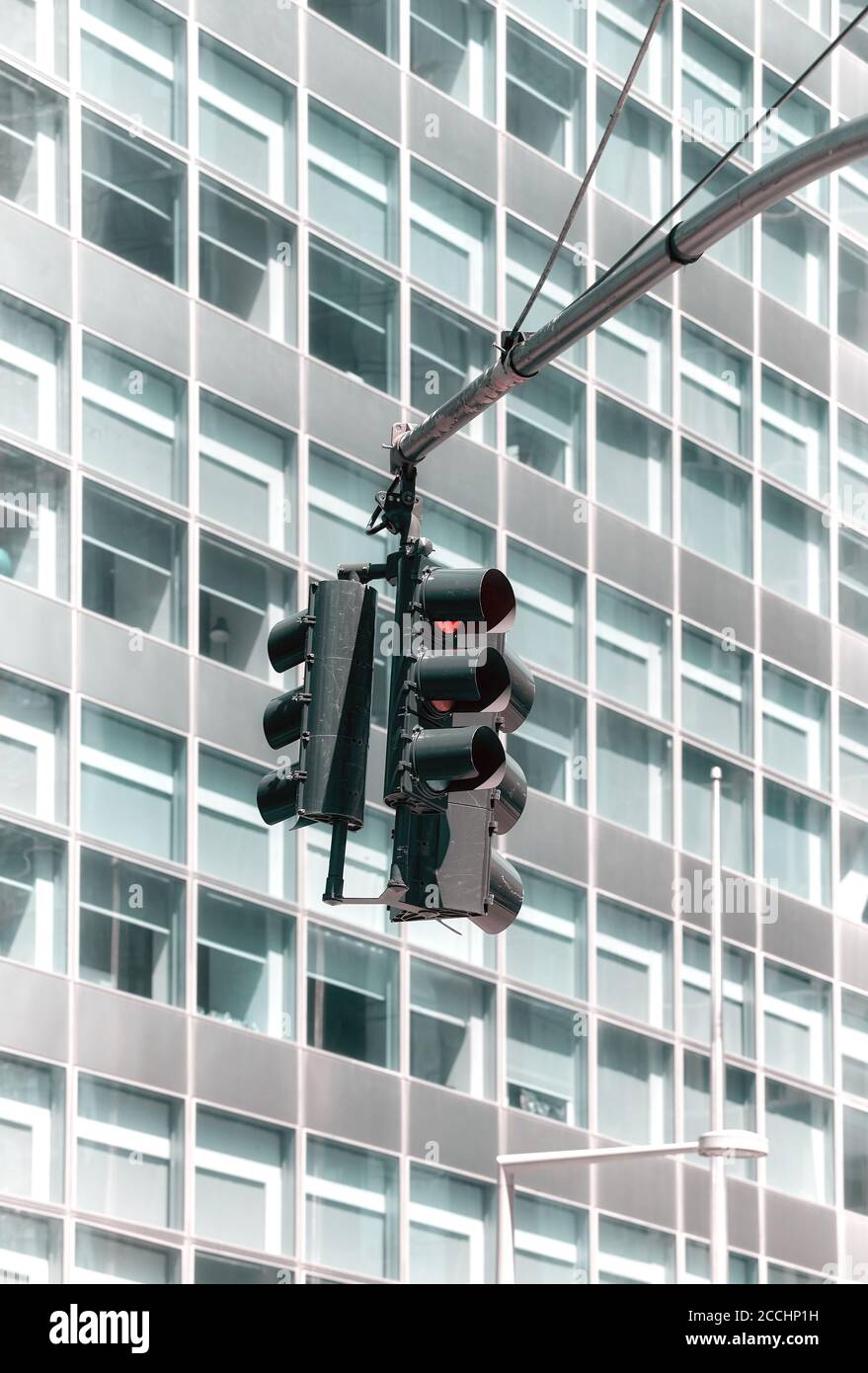 Semafori con un moderno edificio di uffici sullo sfondo, messa a fuoco selettiva, tonalità di colore applicate. Foto Stock