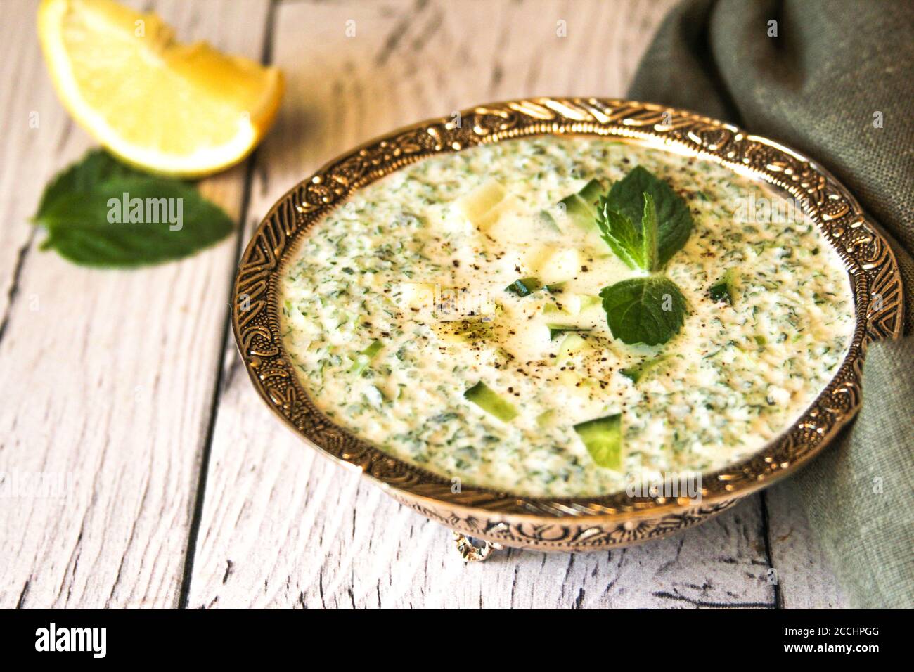 La salsa è composta da kefir, cetriolo verde e limone. Un piatto di cucina iraniana. Snack con patatine. Foto Stock