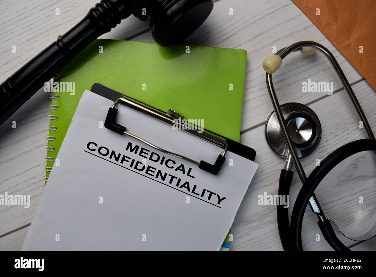 Testo di riservatezza medica scrivere su una documentazione e un gavel con stetoscopio isolato sulla scrivania dell'ufficio. Foto Stock