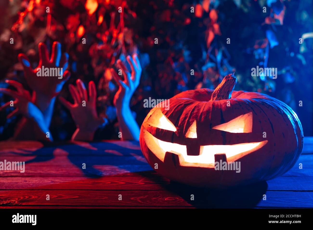 Zucca di Halloween sullo sfondo delle mani di uomini morti. Foto Stock