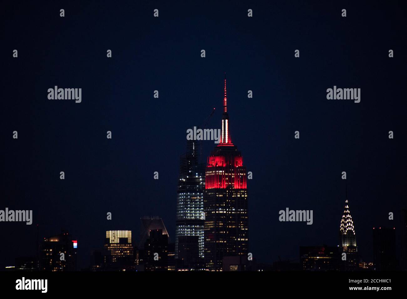Skyline di Manhattan di notte e Empire state Building in sirena luci per ringraziare Covid-19 primi soccorritori al culmine della pandemia di Coronavirus. Foto Stock