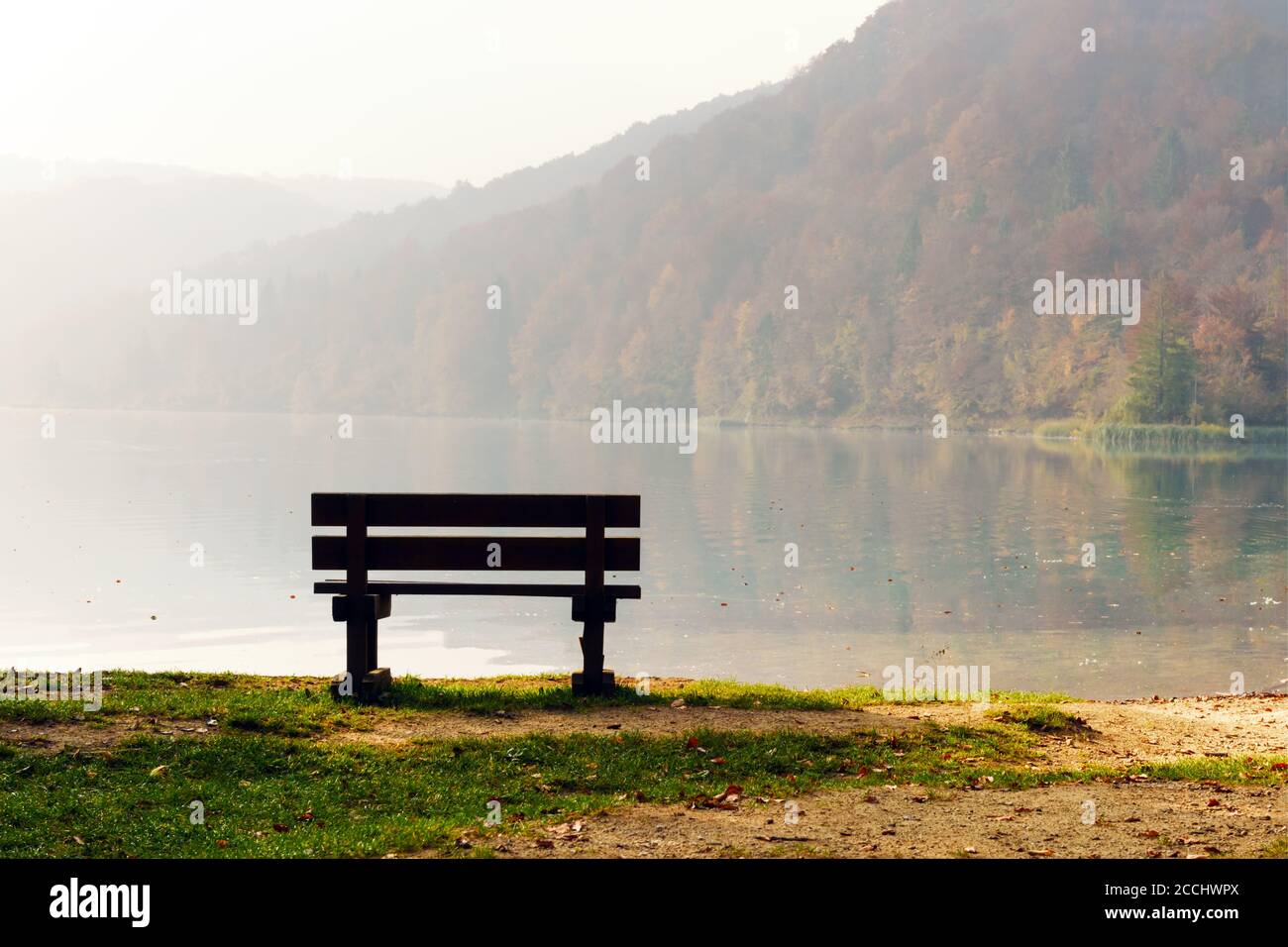 Nebbia mattutina sugli splendidi laghi di Plitvice. Panca di legno sulla costa del lago. Parco Nazionale di Plitvice, Croazia. Fotografia di paesaggio Foto Stock