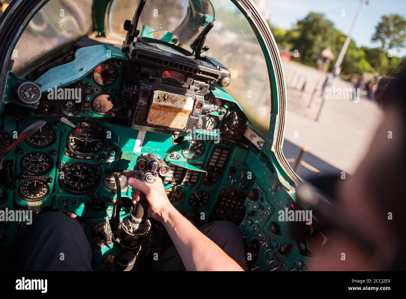 Persona irriconoscibile che tiene il joystick mano del vecchio militare sovietico Mig-21 jet aereo parcheggio nel parco vicino al museo militare, Kiev, Ucraina Foto Stock