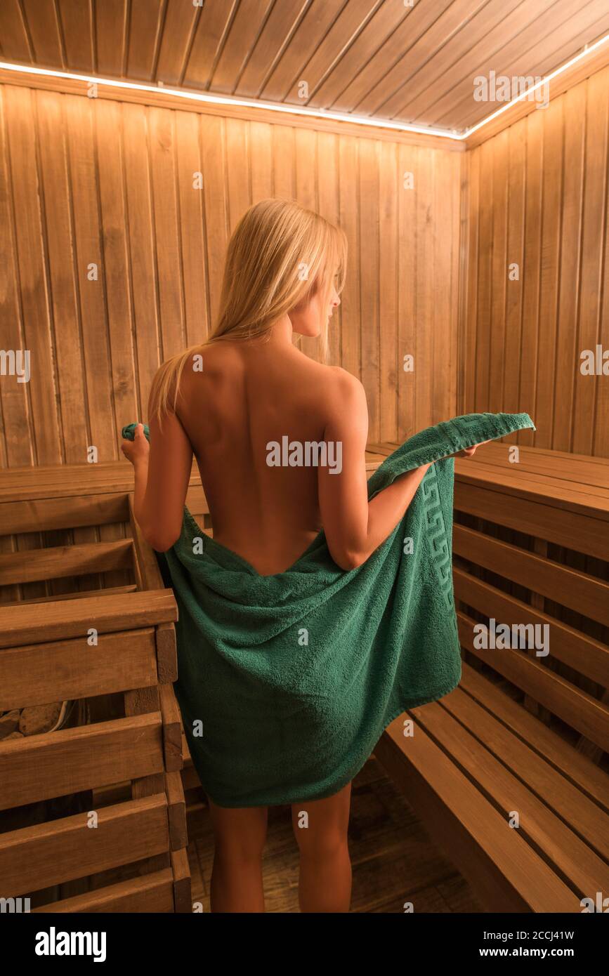 Il giovane blondie si rilassa nella sauna Foto Stock