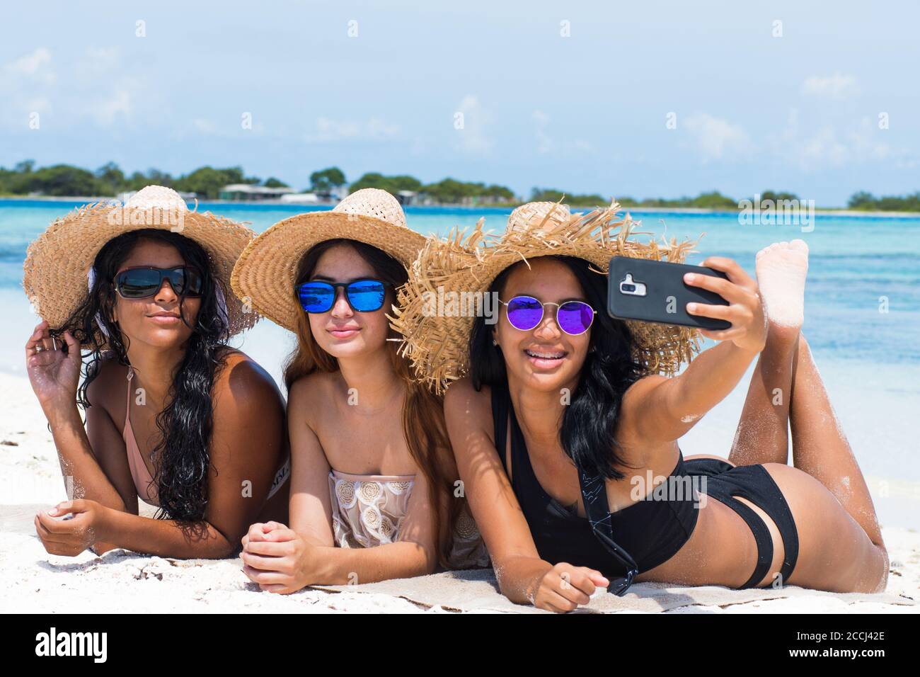 etnia mista donne amici insieme godere di scattare foto selfie a. Spiaggia dei caraibi a Los Roques Venezuela Foto Stock