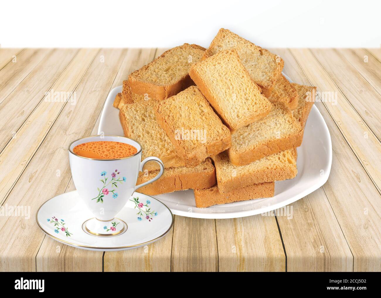 Croccante Rustk o pane tostato per una vita sana, vassoio di biscotti tradizionali con tè, toast per la colazione e tazza di latte fresco e tè, pane tostato secco, croccante Foto Stock