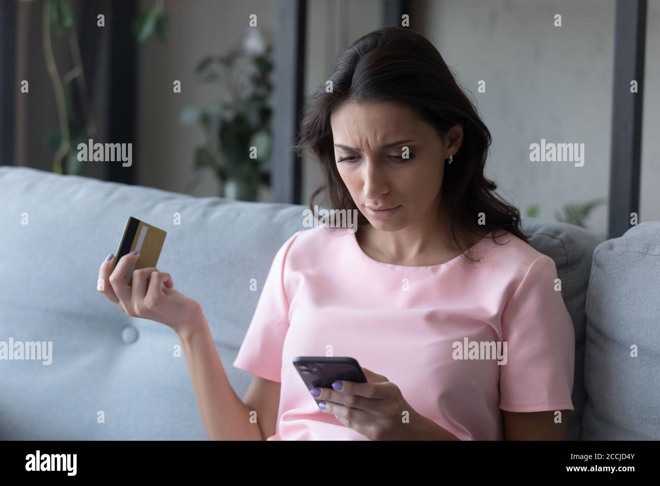 La donna etnica infelice ha problemi a pagare in linea Foto Stock