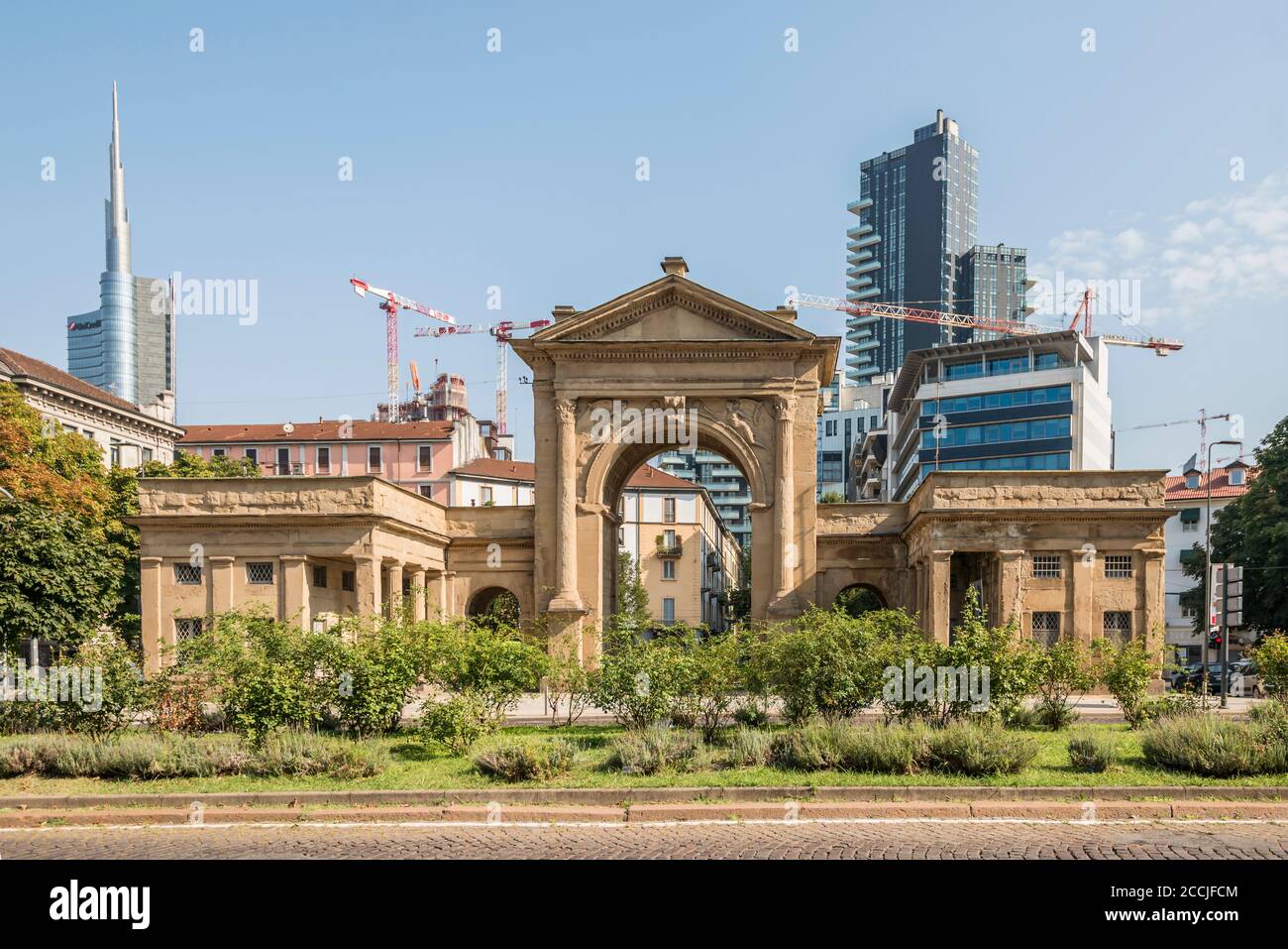 MILANO, ITALIA - Agosto 20 2020: Paesaggio urbano con nuovi grattacieli di centro commerciale sviluppo urbano che incombe fuori dall'ingresso monumentale della città, girato su augus Foto Stock