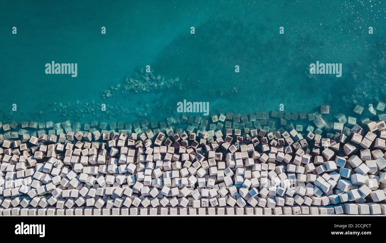Vista aerea dei blocchi di cemento cubo proteggere la riva dalle onde nel porto di Malaga, Spagna. Foto Stock