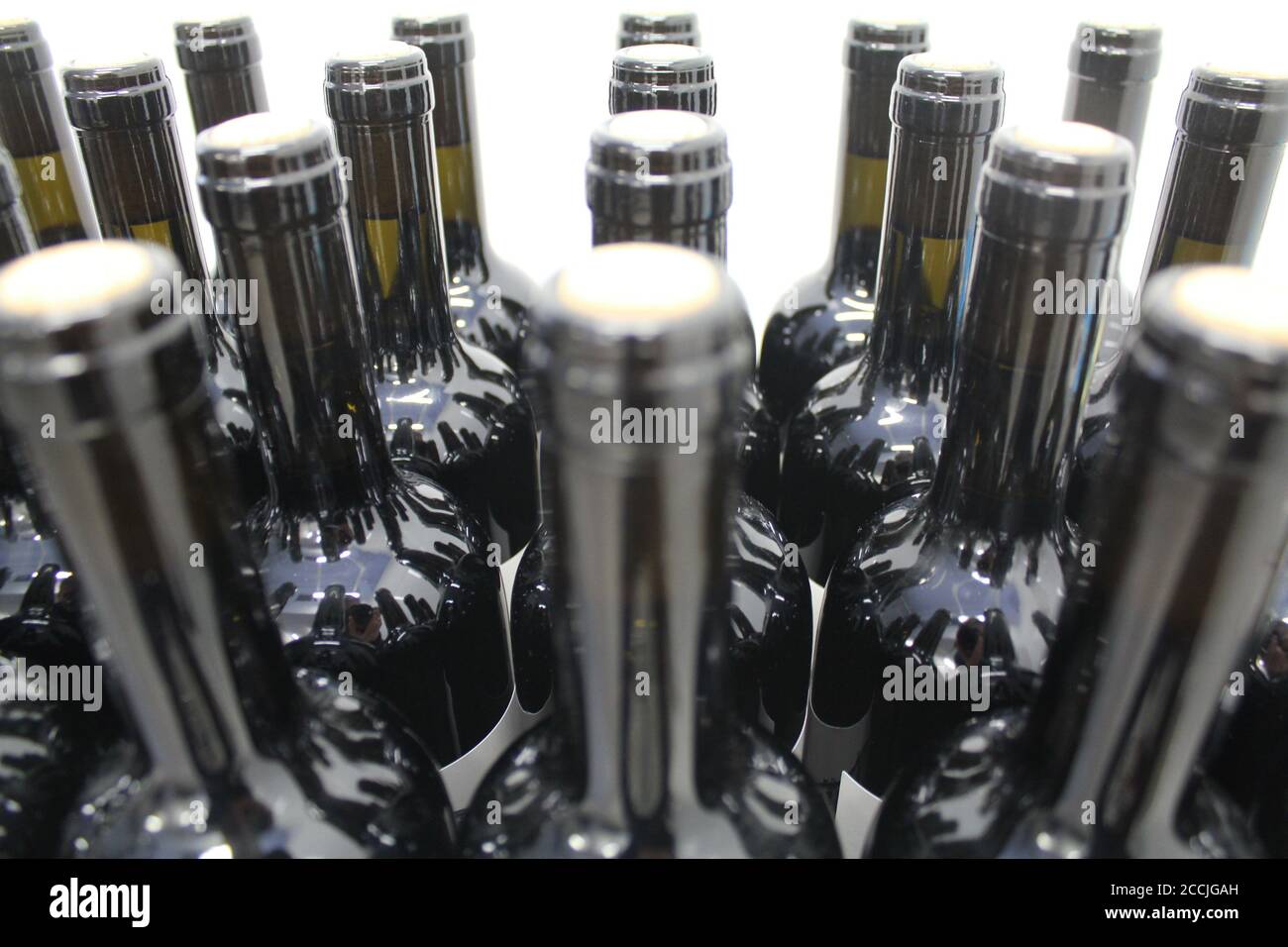 Bottiglie di vetro accatastate in una fabbrica di vino. Foto Stock