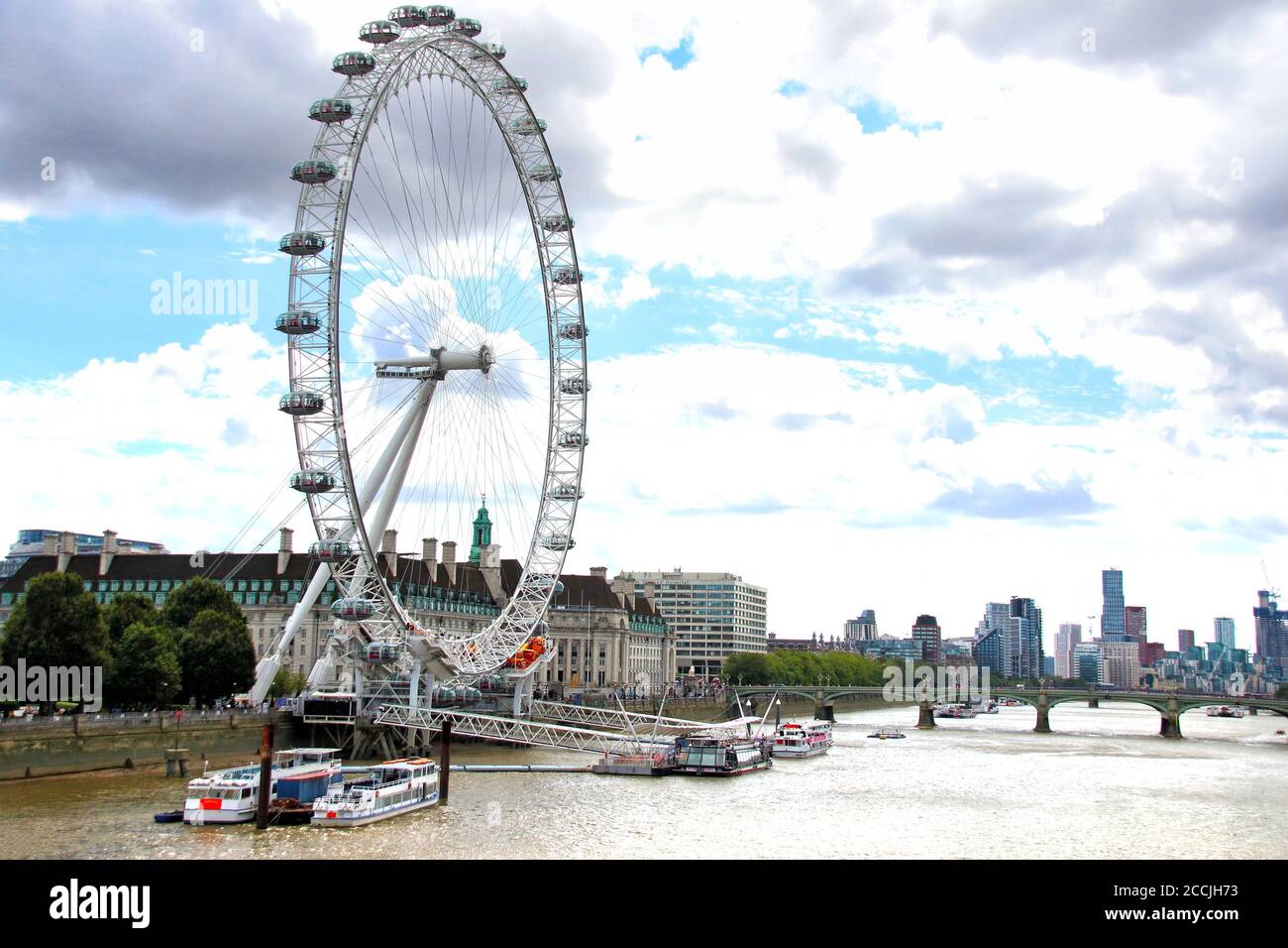 London Eye, visto dall'altro lato del Tamigi. Il lastminute.com London Eye è una delle principali attrazioni turistiche della capitale ed è stato riaperto solo nel mese scorso con un carico di passeggeri ridotto. Le code non sono ai livelli precedenti ma raggiungono all'esterno. I visitatori devono comunque indossare maschere per viaggiare. Foto Stock