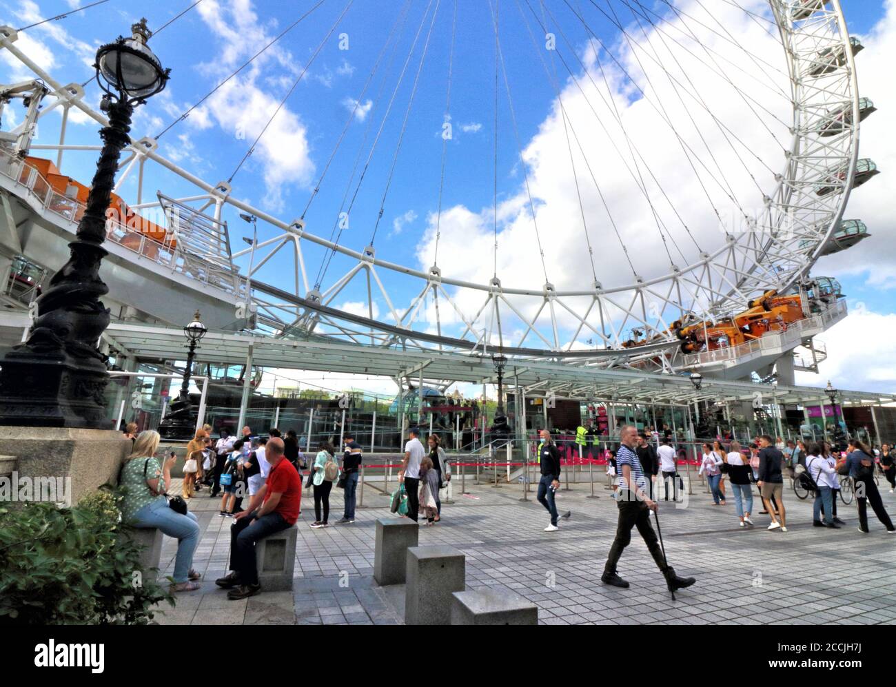 Molte persone intorno all'ingresso del London Eye. Il lastminute.com London Eye è una delle principali attrazioni turistiche della capitale ed è stato riaperto solo nel mese scorso con un numero ridotto di passeggeri. Le code non sono ai livelli precedenti ma raggiungono all'esterno. I visitatori devono comunque indossare maschere per viaggiare. Foto Stock