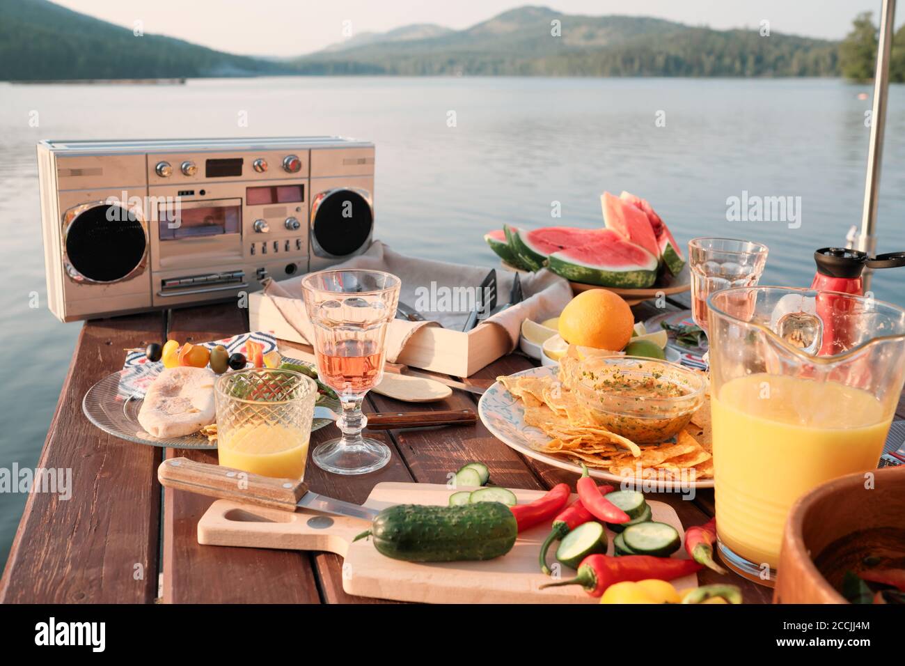 Immagine del tavolo da pranzo con spuntini, frutta e succo di frutta la festa su un molo all'aperto Foto Stock