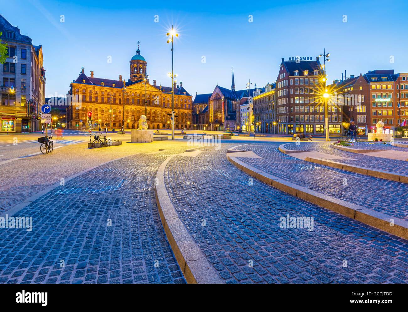 Tramonto a piazza Dam Amsterdam Paesi Bassi. Il palazzo reale è illuminato. Meta turistica popolare. Foto Stock