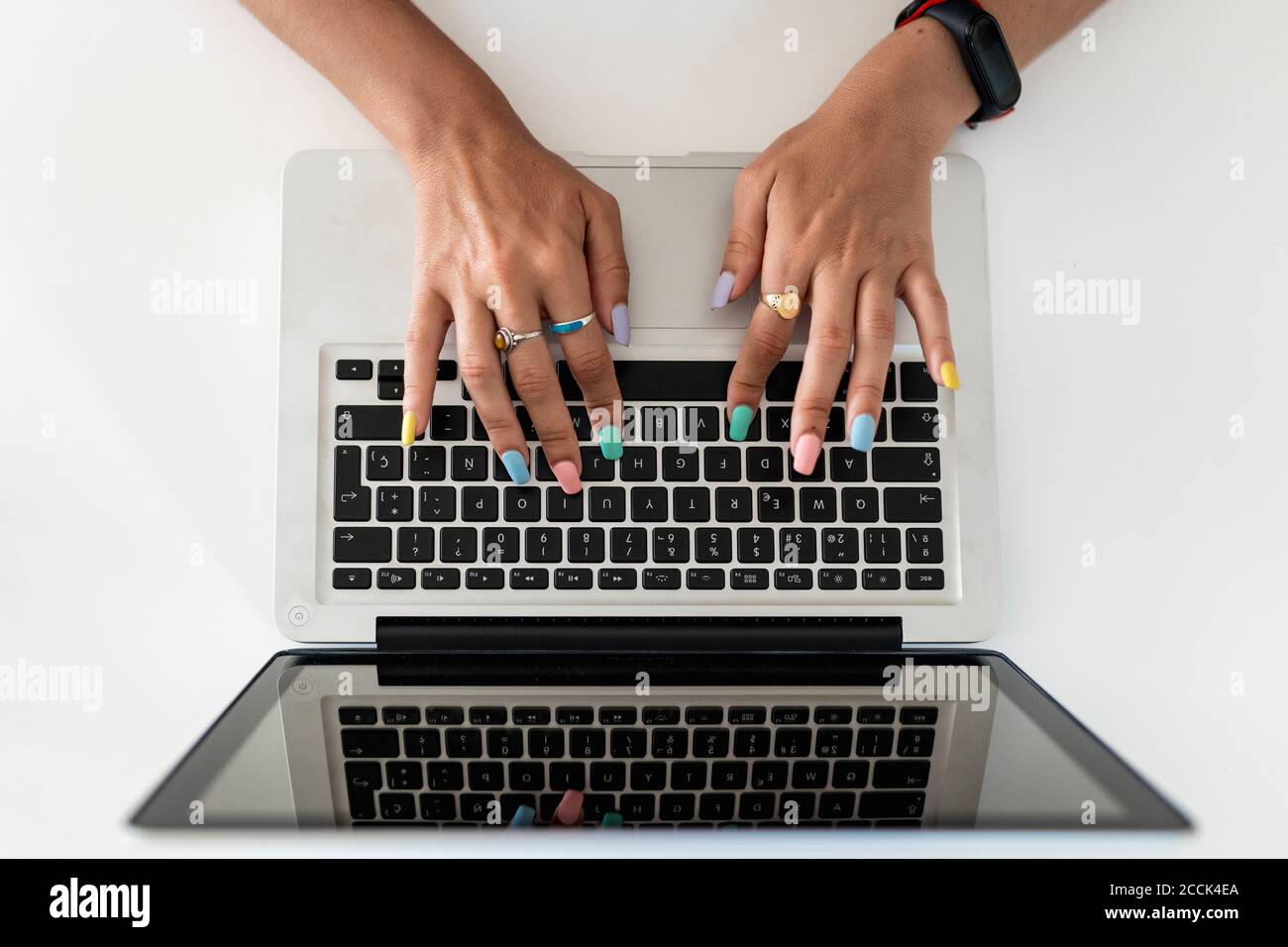 Primo piano delle mani della donna che usano il laptop sul tavolo a casa Foto Stock
